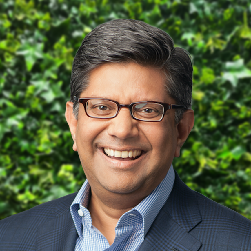 Smiling man wearing glasses and suit outdoors